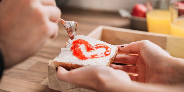 crop-couple-making-toast-with-jam